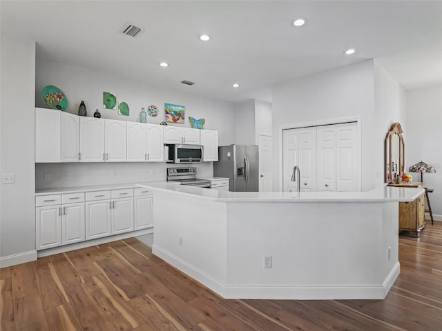 kitchen with dark wood-style floors, visible vents, light countertops, appliances with stainless steel finishes, and white cabinetry