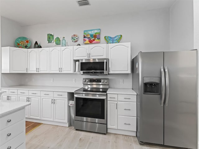 kitchen with visible vents, white cabinetry, appliances with stainless steel finishes, light wood finished floors, and light countertops