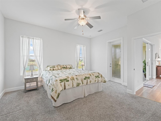 carpeted bedroom featuring multiple windows, baseboards, and visible vents