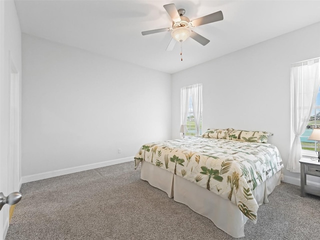 carpeted bedroom with ceiling fan and baseboards