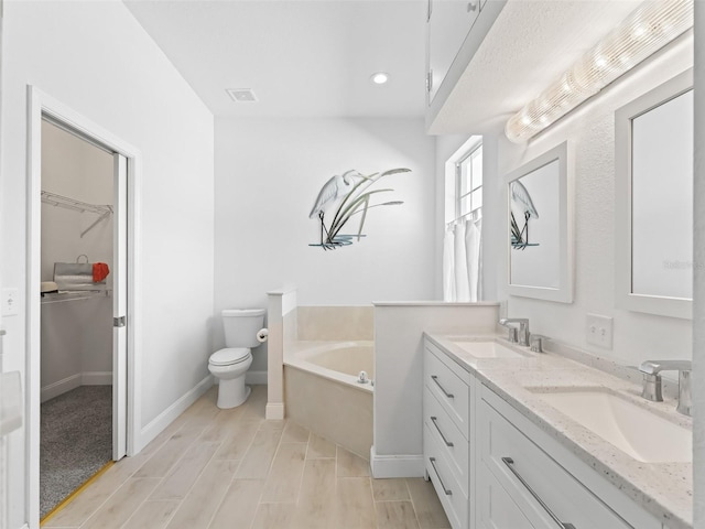 full bathroom with a sink, a garden tub, double vanity, and toilet