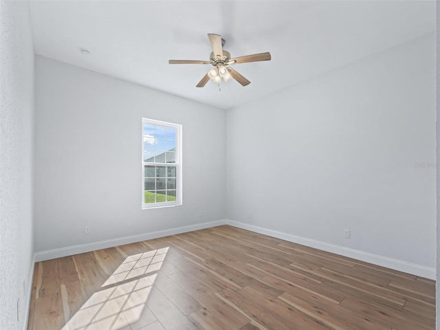 unfurnished room featuring ceiling fan, baseboards, and wood finished floors