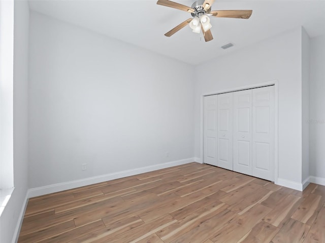 unfurnished bedroom featuring baseboards, visible vents, a closet, and light wood-type flooring