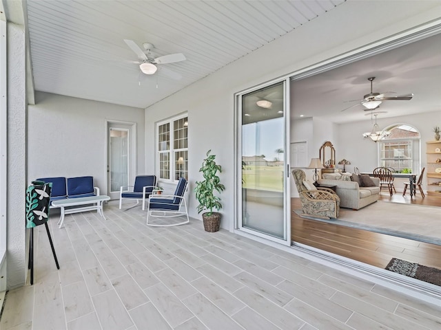 sunroom / solarium with ceiling fan with notable chandelier