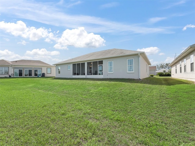 rear view of house with a yard and stucco siding