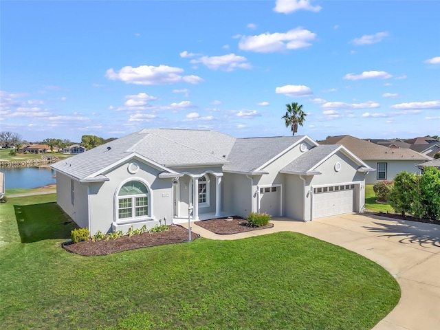 ranch-style house featuring an attached garage, stucco siding, a front lawn, concrete driveway, and a water view