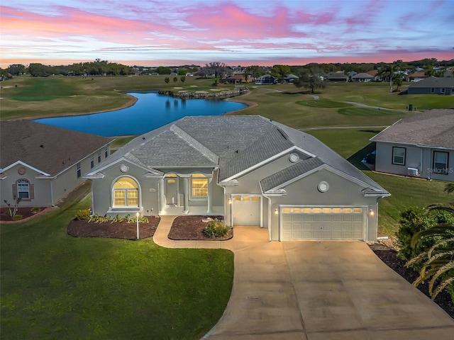 view of front of home featuring a garage, a water view, driveway, and stucco siding