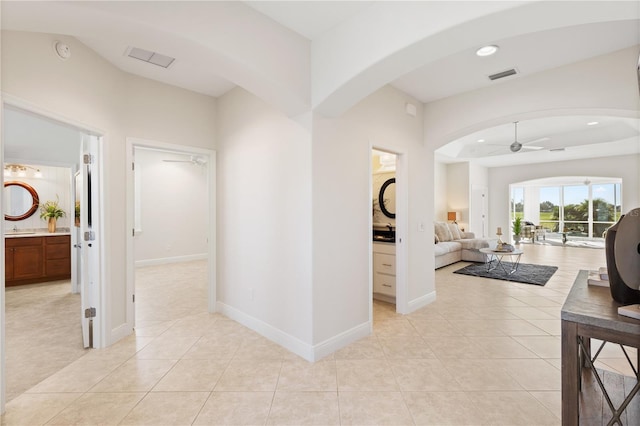 hall featuring sink and light tile patterned floors