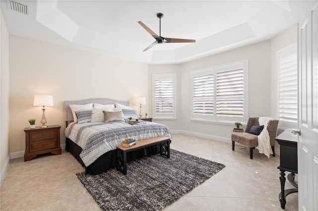 bedroom featuring light tile patterned floors, ceiling fan, and a tray ceiling