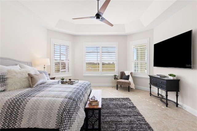 tiled bedroom featuring ceiling fan and a tray ceiling