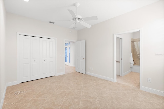 unfurnished bedroom with ensuite bath, a closet, ceiling fan, and light tile patterned flooring