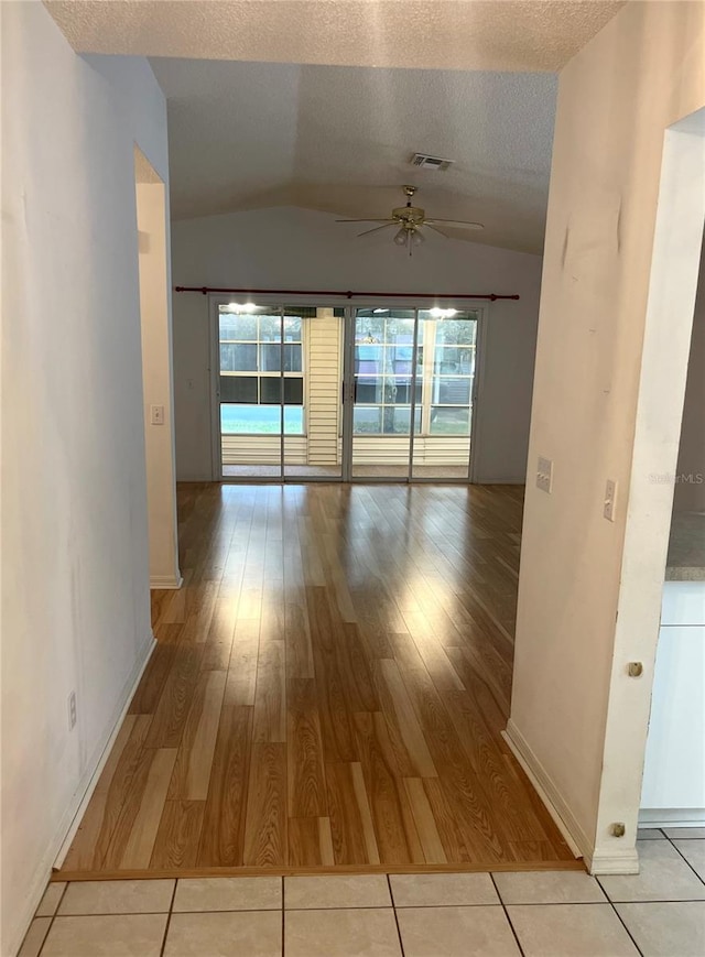 spare room featuring visible vents, a ceiling fan, wood finished floors, and lofted ceiling