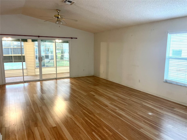 unfurnished room featuring ceiling fan, plenty of natural light, and wood finished floors