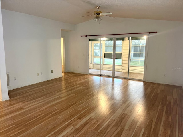 spare room featuring visible vents, a ceiling fan, vaulted ceiling, and wood finished floors