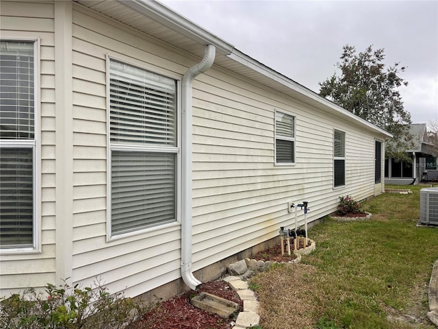 view of side of property featuring a yard and cooling unit