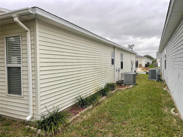view of property exterior featuring cooling unit and a yard