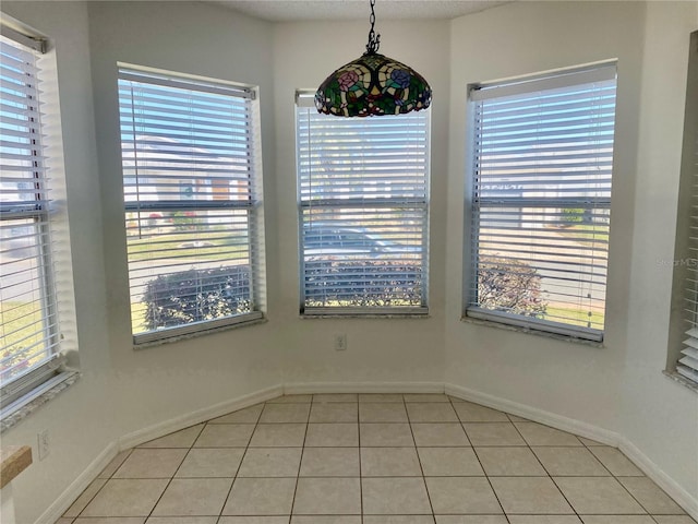 unfurnished dining area featuring light tile patterned flooring and baseboards