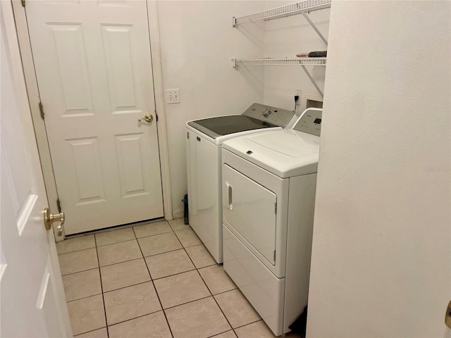 laundry area featuring light tile patterned floors, independent washer and dryer, and laundry area