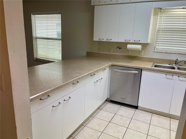 kitchen with a sink, light tile patterned floors, a wealth of natural light, and dishwasher