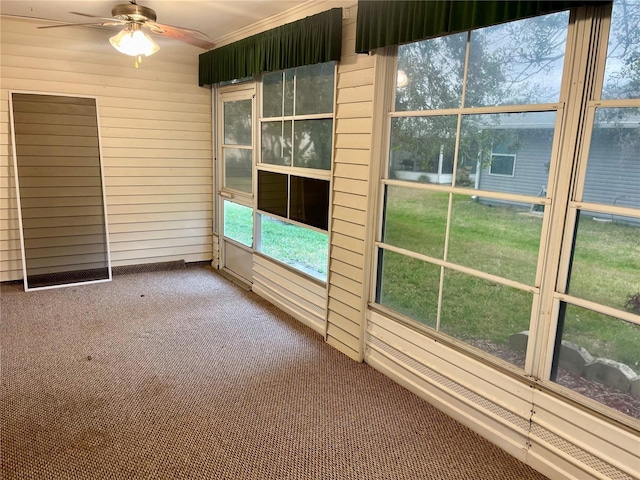 unfurnished sunroom with ceiling fan