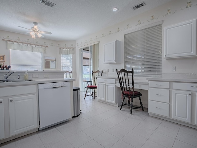 kitchen with dishwasher, sink, and white cabinets