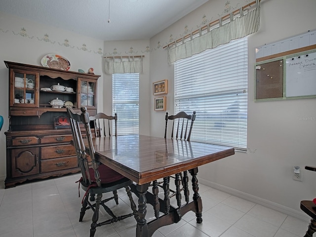 tiled dining area with a textured ceiling