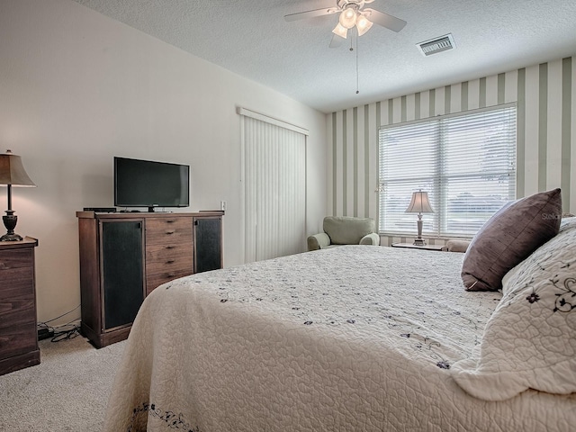 bedroom featuring ceiling fan, carpet, and a textured ceiling