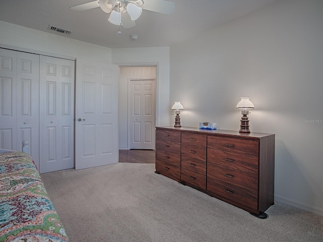 bedroom with ceiling fan, a closet, and light carpet