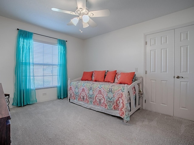 carpeted bedroom with a textured ceiling and ceiling fan