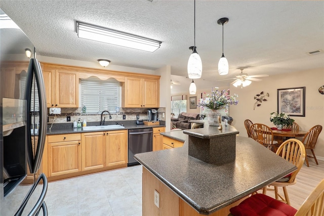 8373 SE 177th Bartram Loop, The Villages, FL 32162 - kitchen featuring pendant lighting, sink, appliances with stainless steel finishes, a center island, and decorative backsplash