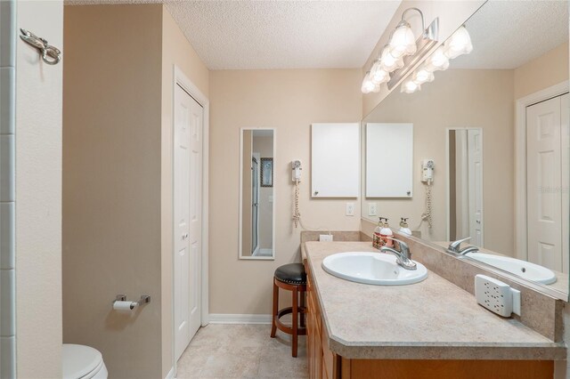 8373 SE 177th Bartram Loop, The Villages, FL 32162 - bathroom with tile patterned floors, vanity, toilet, and a textured ceiling