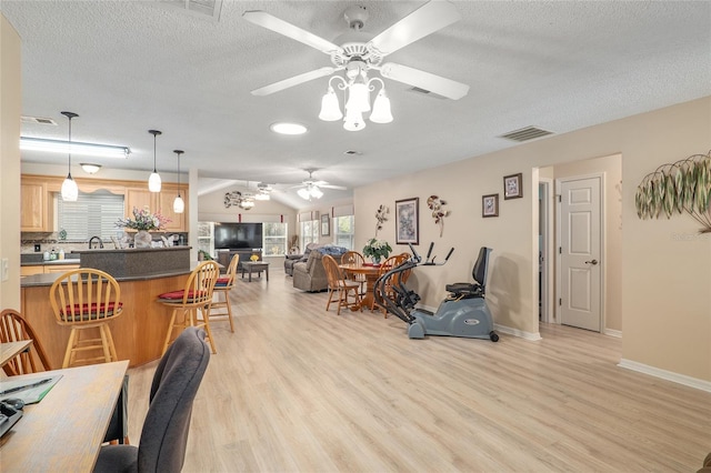 8373 SE 177th Bartram Loop, The Villages, FL 32162 - living room featuring ceiling fan, lofted ceiling, a textured ceiling, and light wood-type flooring