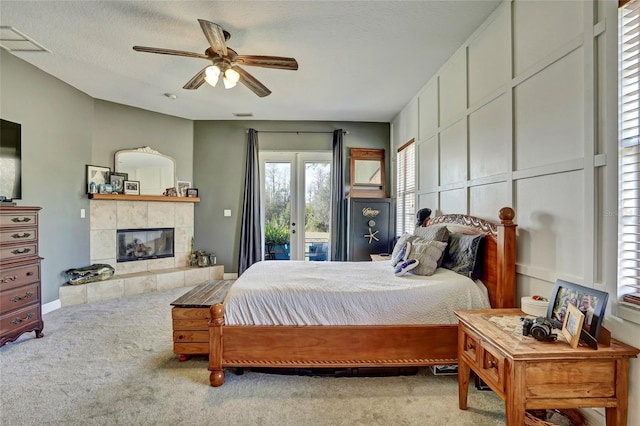 carpeted bedroom with ceiling fan, a fireplace, a textured ceiling, and access to outside