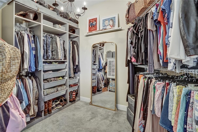 spacious closet featuring light colored carpet and a chandelier