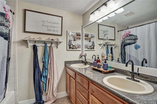 bathroom with tile patterned flooring, vanity, shower / bathtub combination with curtain, and a textured ceiling