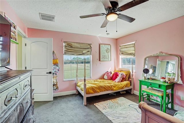 bedroom with ceiling fan, carpet floors, and a textured ceiling