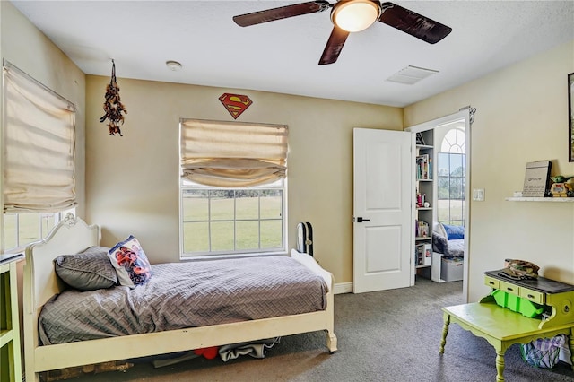 carpeted bedroom featuring ceiling fan and multiple windows