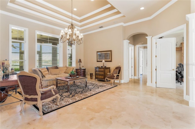 living room with crown molding, a towering ceiling, a tray ceiling, and a chandelier