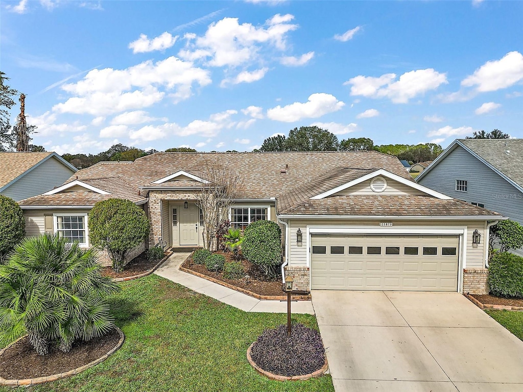 ranch-style home with a garage and a front lawn