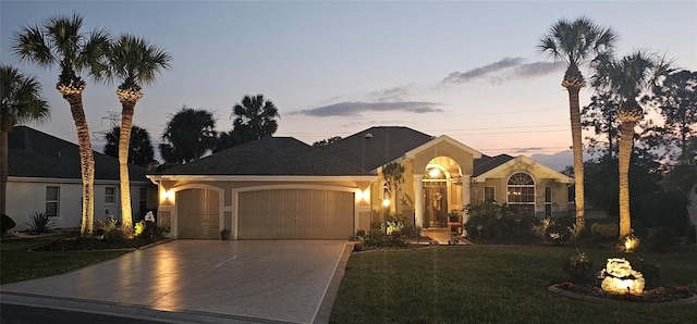 view of front of house featuring a garage and a yard