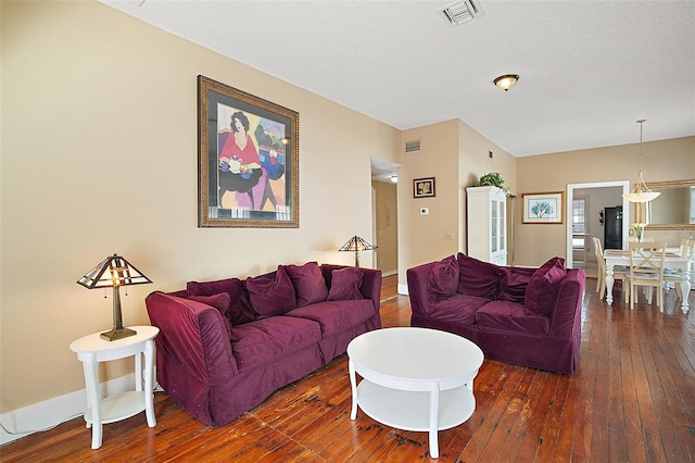 living room featuring dark hardwood / wood-style floors and a textured ceiling