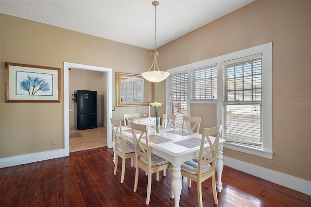 dining room with hardwood / wood-style floors and a textured ceiling