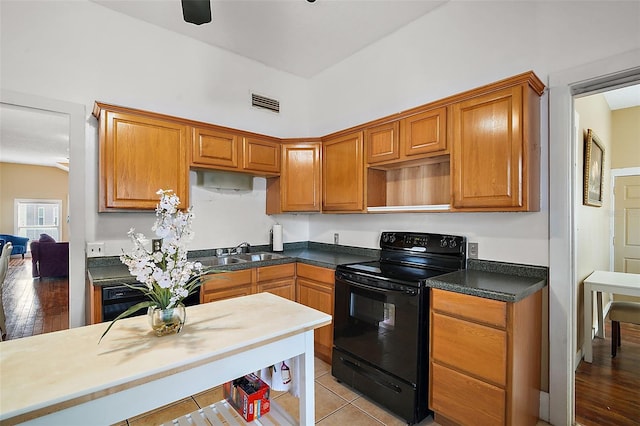 kitchen with light tile patterned floors, sink, and black appliances