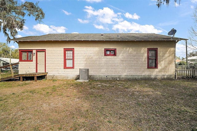 back of house with a lawn and central air condition unit