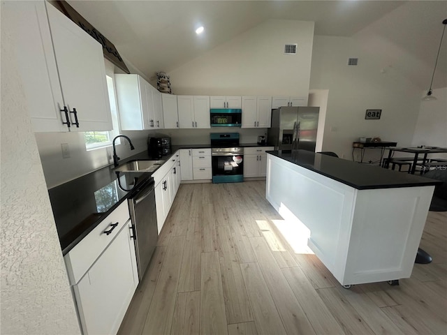 654 NW 9th Ave, Webster, FL 33597 - kitchen with appliances with stainless steel finishes, light wood finished floors, dark countertops, and high vaulted ceiling