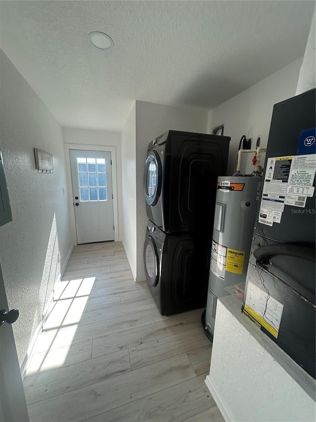 654 NW 9th Ave, Webster, FL 33597 - laundry room with estacked washer and dryer, electric water heater, a textured ceiling, light wood-style flooring, and a textured wall