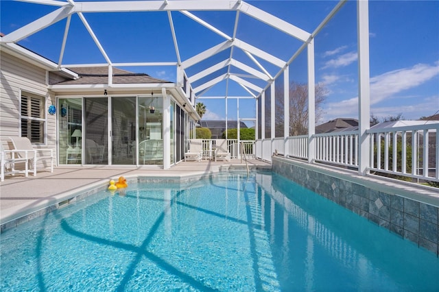 view of pool featuring glass enclosure and a patio