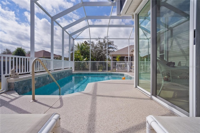 view of swimming pool featuring a patio area and glass enclosure