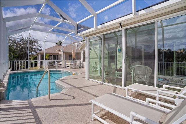 view of swimming pool featuring a patio and glass enclosure