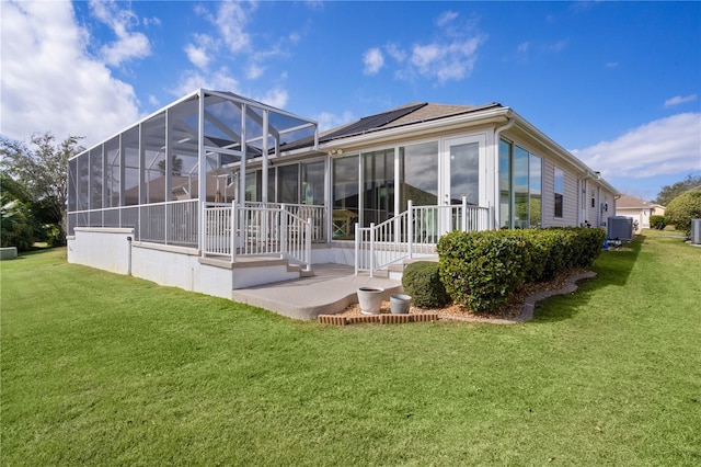 back of house with a yard, a patio, solar panels, and cooling unit